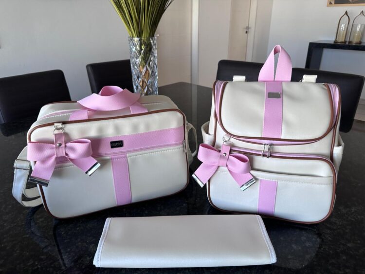 bolsa maternidade com mochila e trocador em um pérola com faixa rosa bebê