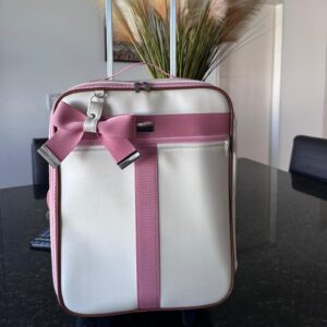 mala de rodinha em um pérola com faixa rosa antigo